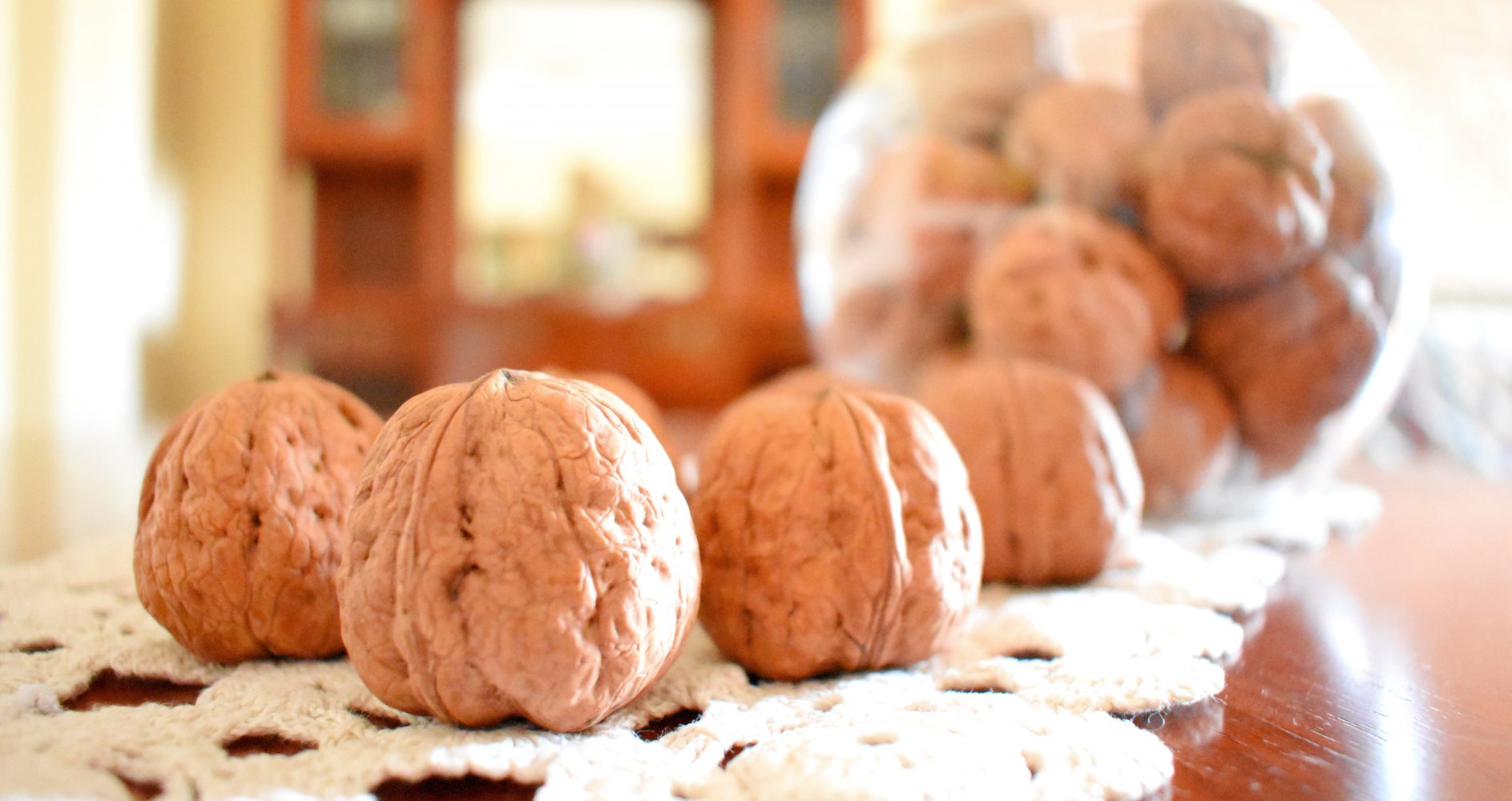 Quattro noci intere con guscio disposte in fila | Four whole walnuts in their shells arranged in a row