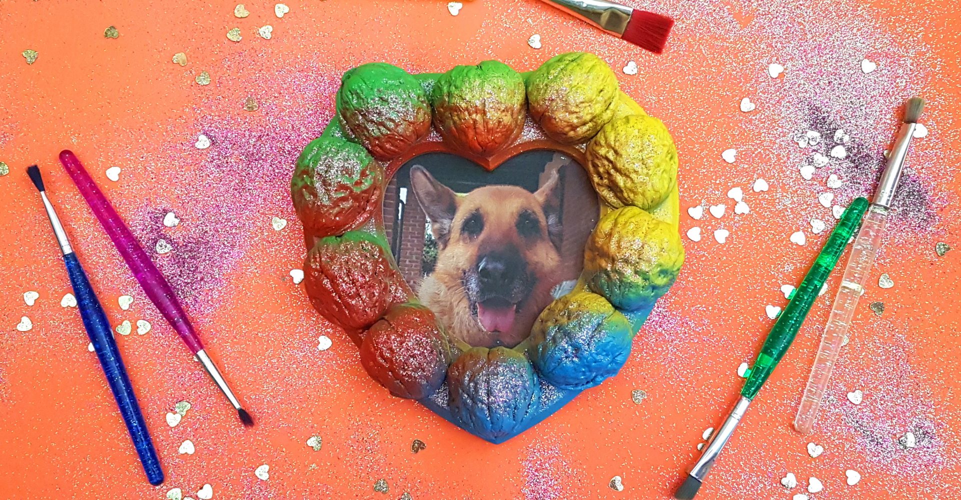 Cornice a cuore fatta a mano con noci colorate e brillantini, contenente la foto di un cane - Handmade heart-shaped frame with colored walnuts and glitter, containing a photo of a dog