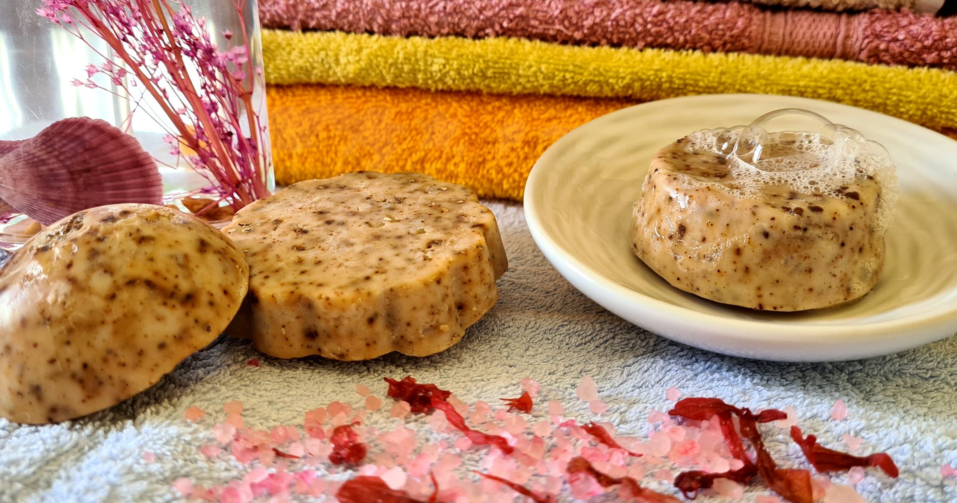 Saponette artigianali disposte con gusci di noce su asciugamani colorati - Handmade soaps arranged with walnut shells on colorful towels