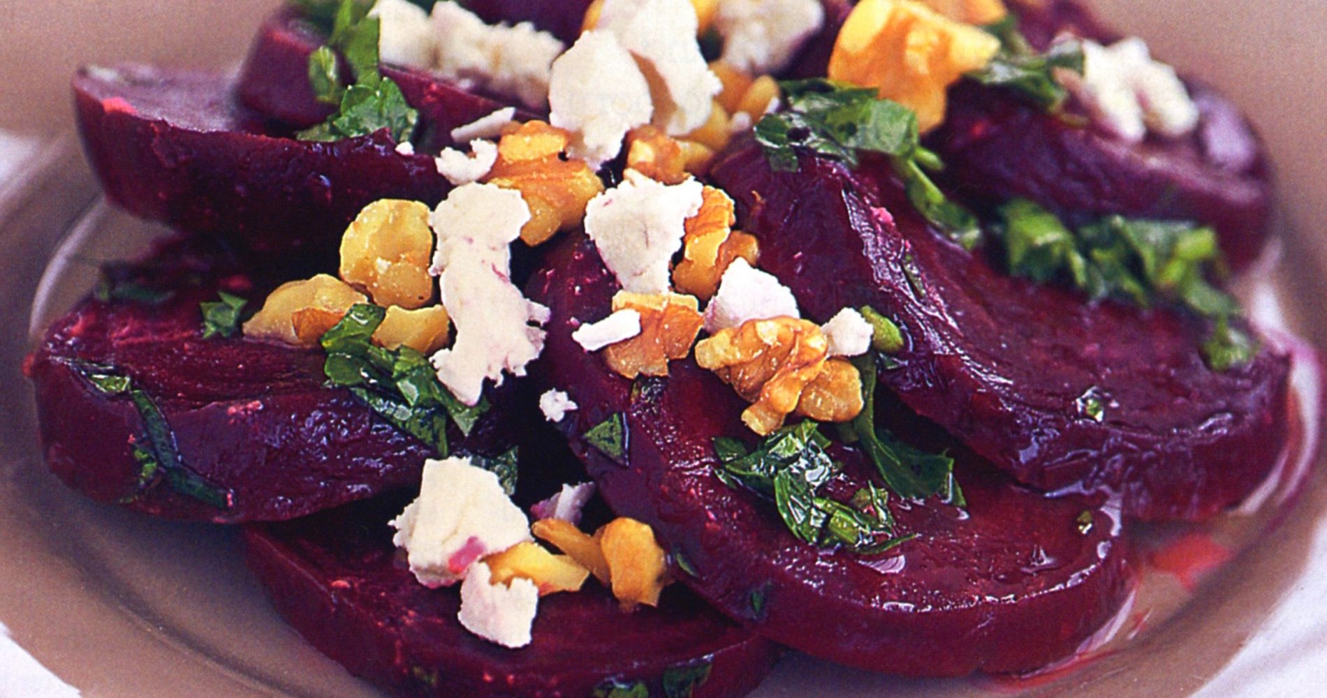 Primo piano di un'insalata di barbabietole con formaggio, noci e fette di barbabietola rossa - Close-up of a beet salad with cheese, walnuts, and slices of red beetroot